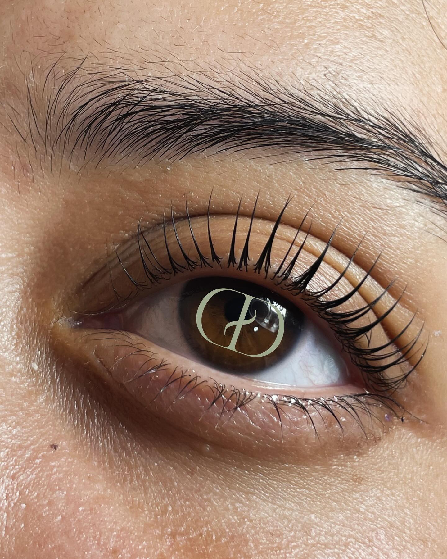 Primer plano de un ojo con lifting de pestañas y el monograma CD de Cincya Díaz